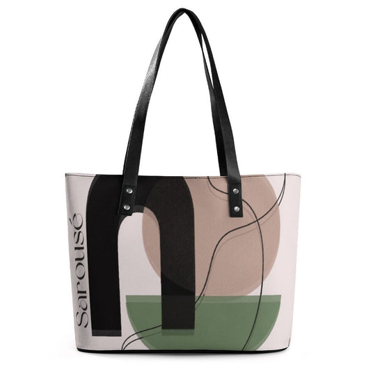 A Sarouse tote bag featuring an abstract geometric print with black, beige, and sage green shapes on a light pink background, complete with black faux-leather shoulder straps.